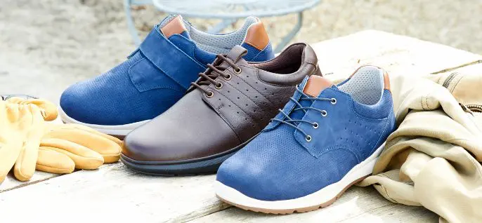 A trio of men's trainers in different colours and fastenings on a table